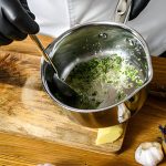 chef préparant une sauce avec le poivre blanc